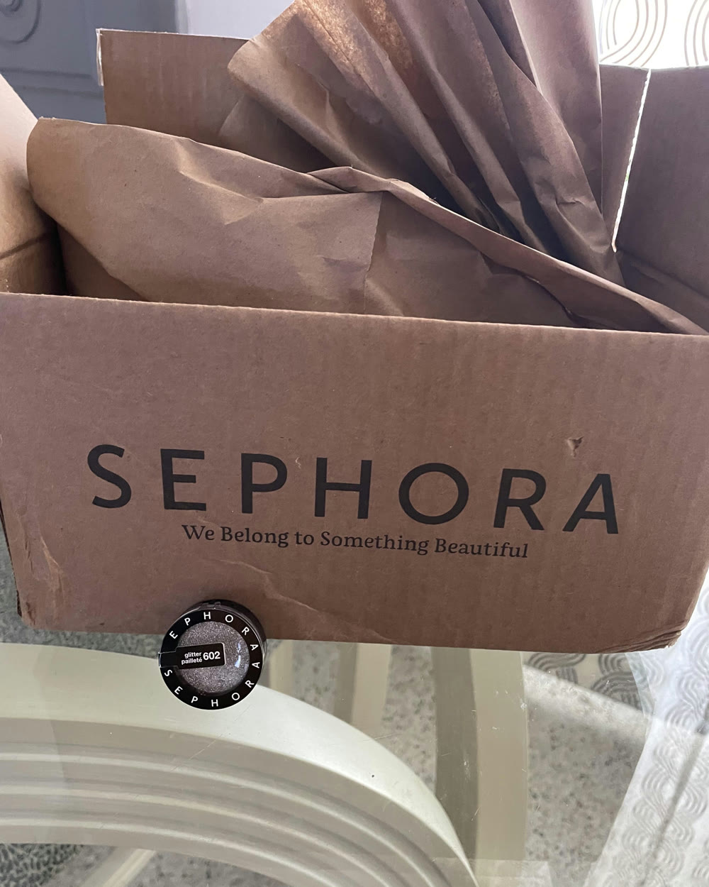 Un carton Sephora ouvert, papier de soie et produit scellé.